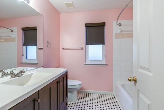 full bathroom featuring toilet, tiled shower / bath, and vanity