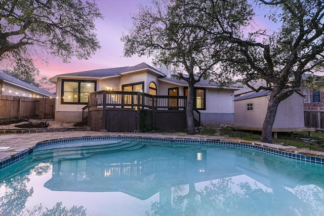 pool at dusk featuring a deck