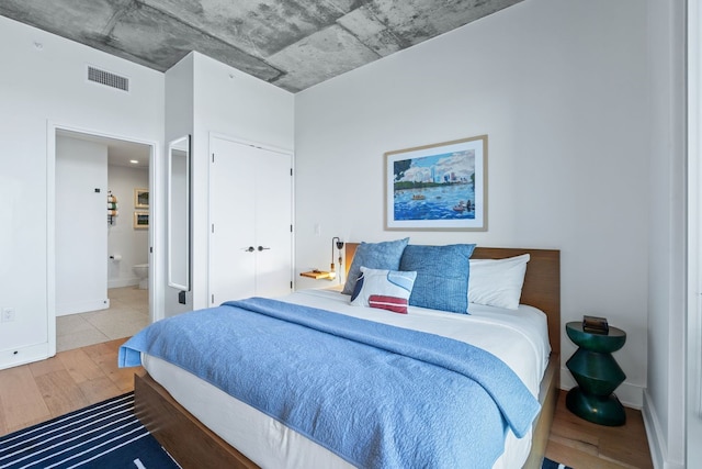 bedroom featuring hardwood / wood-style floors and ensuite bath