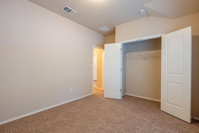 unfurnished bedroom with vaulted ceiling, carpet floors, and a closet