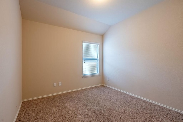 carpeted empty room featuring lofted ceiling