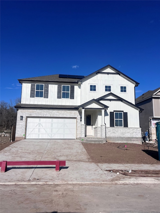 view of front facade with a garage and solar panels