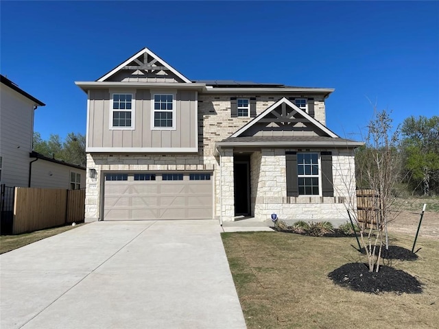 17308 Astral Ln, Manor, TX 78653 - view of front facade featuring board and batten siding, an attached garage, solar panels, concrete driveway, and stone siding