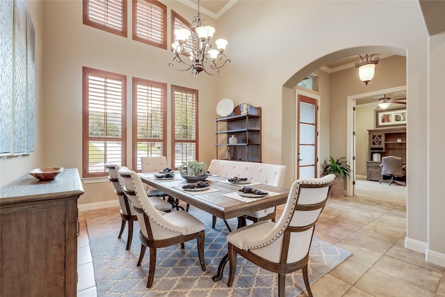 dining area with a high ceiling, light tile patterned floors, crown molding, and plenty of natural light