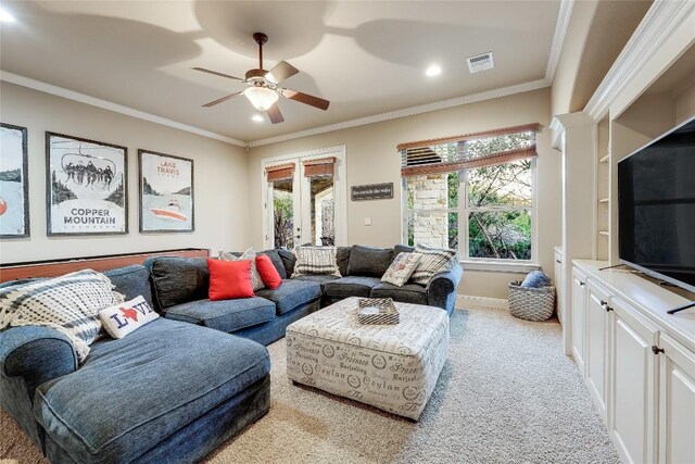 living room with ceiling fan, light colored carpet, and crown molding