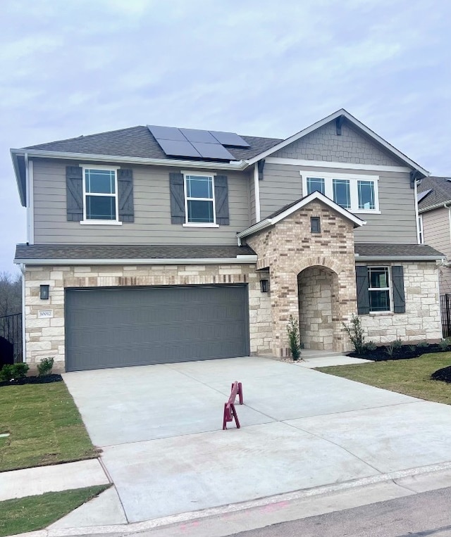 view of front of property featuring a garage and solar panels