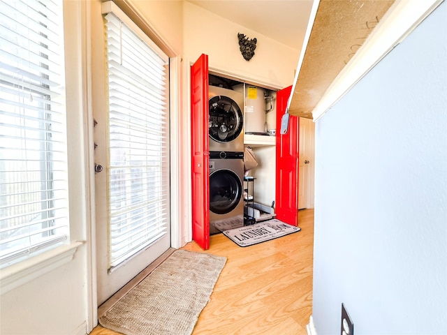 washroom with stacked washer / dryer and wood-type flooring