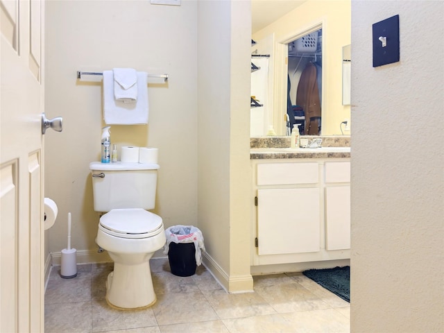 bathroom featuring toilet, tile patterned flooring, and vanity