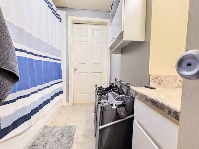 interior space featuring light tile patterned floors and white cabinets