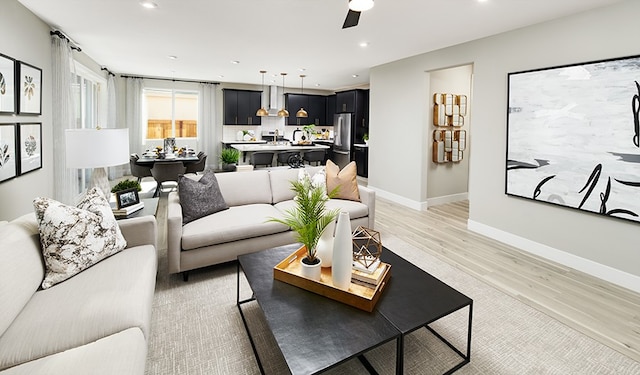 living room with ceiling fan and light hardwood / wood-style flooring