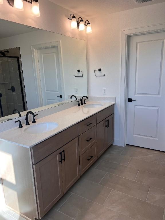 bathroom featuring tiled shower and vanity