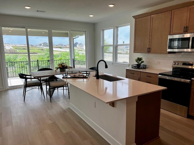 17108 Vernal Rd, Manor, TX 78653 - kitchen with appliances with stainless steel finishes, light wood-type flooring, backsplash, light countertops, and recessed lighting