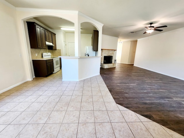 kitchen featuring light tile patterned floors, ceiling fan, white appliances, ornamental molding, and dark brown cabinetry