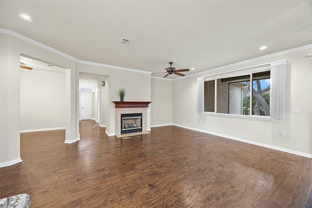 unfurnished living room with dark wood-type flooring, ornamental molding, a fireplace, and ceiling fan