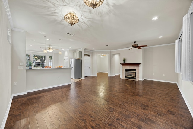 unfurnished living room featuring dark hardwood / wood-style flooring, crown molding, and a tiled fireplace