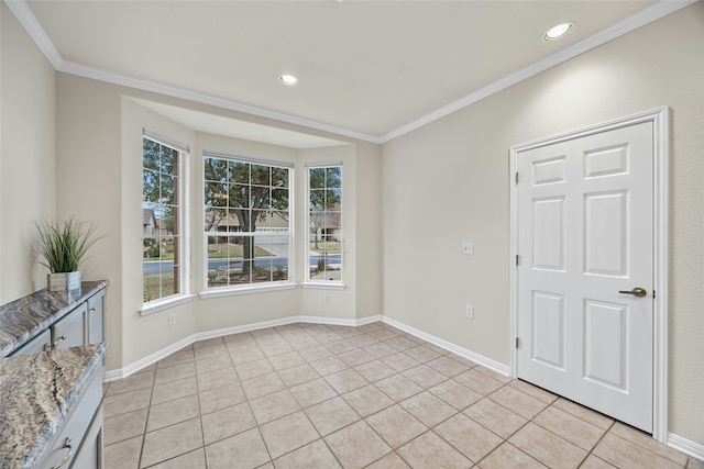 spare room featuring plenty of natural light, light tile patterned flooring, and crown molding