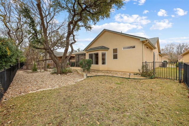 back of property featuring a sunroom and a yard