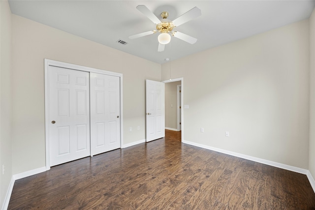 unfurnished bedroom with ceiling fan, a closet, and dark hardwood / wood-style flooring