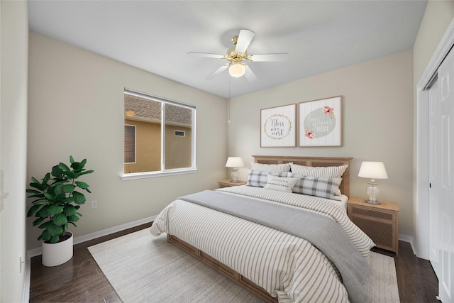 bedroom with dark wood-type flooring, ceiling fan, and a closet