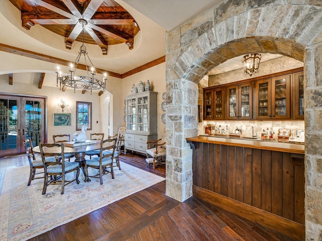 dining area featuring dark wood-type flooring, ornamental molding, plenty of natural light, and french doors