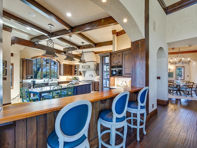 kitchen with kitchen peninsula, wooden counters, dark hardwood / wood-style flooring, and a notable chandelier