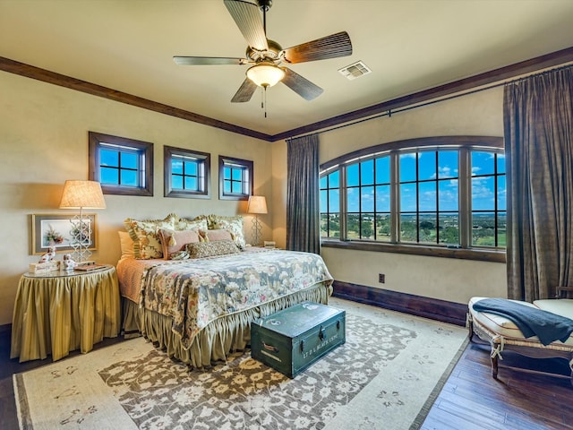 bedroom featuring ceiling fan, crown molding, and wood-type flooring