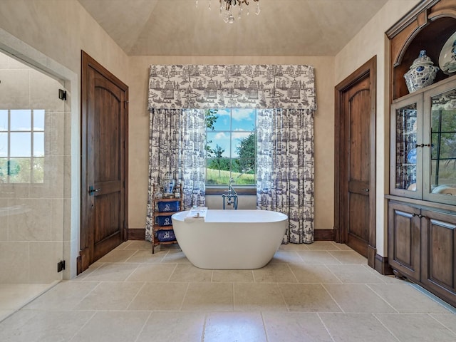 bathroom with independent shower and bath, a healthy amount of sunlight, and a notable chandelier