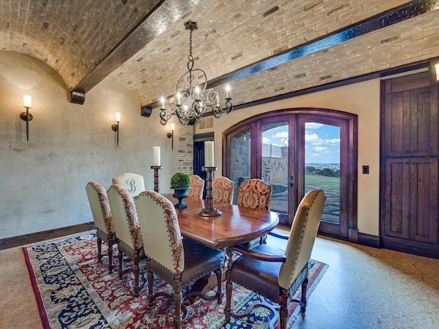 dining space with lofted ceiling, brick ceiling, french doors, and a notable chandelier