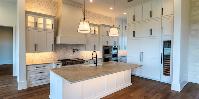 200 E Eldorado Ridge Dr, Fredericksburg, TX 78624 - kitchen with a sink, appliances with stainless steel finishes, dark wood-style flooring, decorative backsplash, and a kitchen island with sink