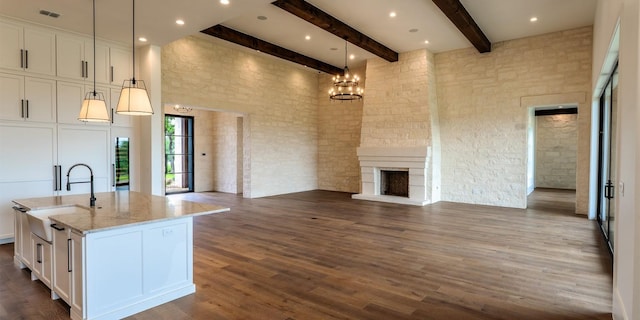 200 E Eldorado Ridge Dr, Fredericksburg, TX 78624 - kitchen featuring open floor plan, beam ceiling, white cabinets, light stone countertops, and a sink