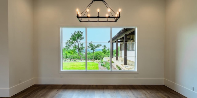 200 E Eldorado Ridge Dr, Fredericksburg, TX 78624 - empty room featuring plenty of natural light, a chandelier, dark wood-style flooring, and baseboards