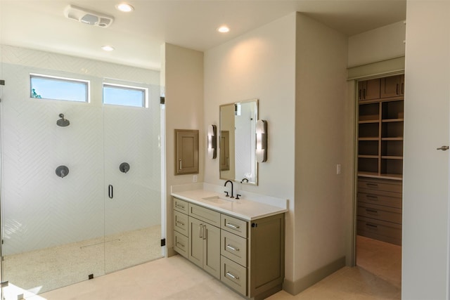 bathroom with a shower with shower door, tile patterned floors, and vanity