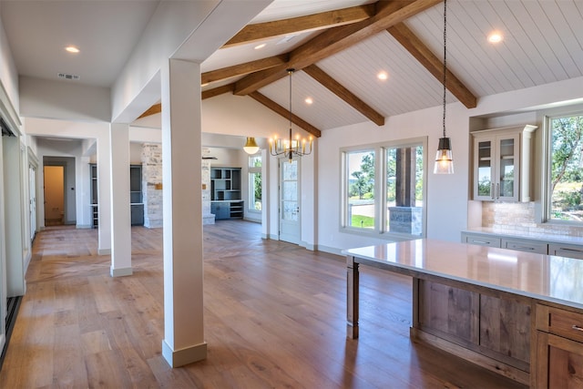 kitchen featuring tasteful backsplash, a notable chandelier, beam ceiling, hanging light fixtures, and light wood-type flooring