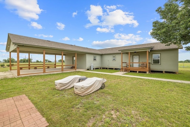 rear view of property featuring a lawn