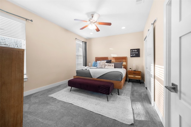 bedroom with ceiling fan, dark carpet, and multiple windows