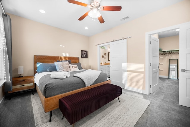 carpeted bedroom with ceiling fan, a walk in closet, a closet, and ensuite bath