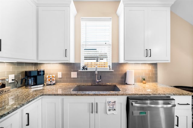 kitchen featuring light stone countertops, white cabinets, sink, backsplash, and stainless steel dishwasher