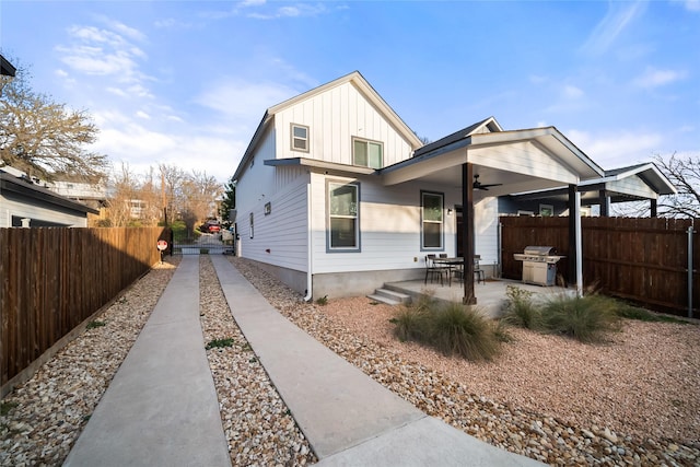 rear view of property with ceiling fan and a patio