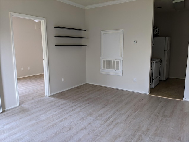 spare room with light hardwood / wood-style floors and crown molding