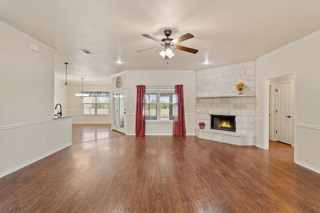 2000 County Road 116b, Burnet, TX 78611 - unfurnished living room featuring crown molding, ceiling fan, a fireplace, wood finished floors, and baseboards