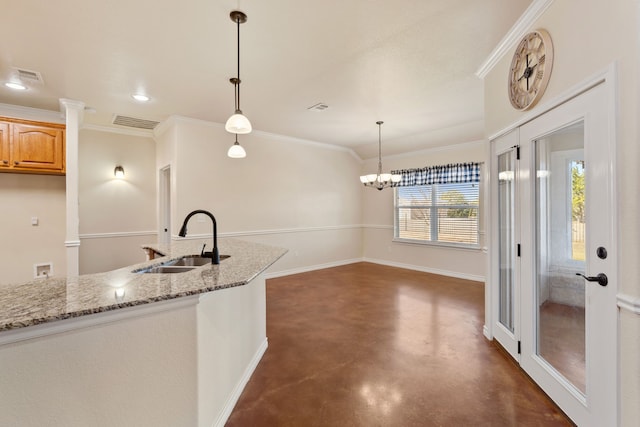 kitchen with decorative light fixtures, a notable chandelier, sink, ornamental molding, and light stone counters