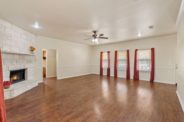 unfurnished living room with ceiling fan, dark wood-type flooring, crown molding, and a fireplace