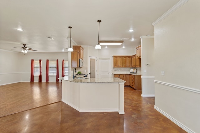 kitchen with concrete flooring, pendant lighting, backsplash, and light stone countertops