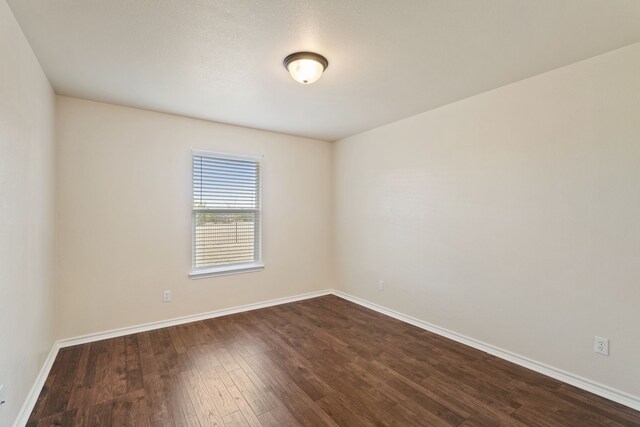 empty room featuring dark wood-type flooring