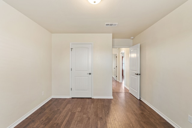 unfurnished bedroom with dark hardwood / wood-style flooring