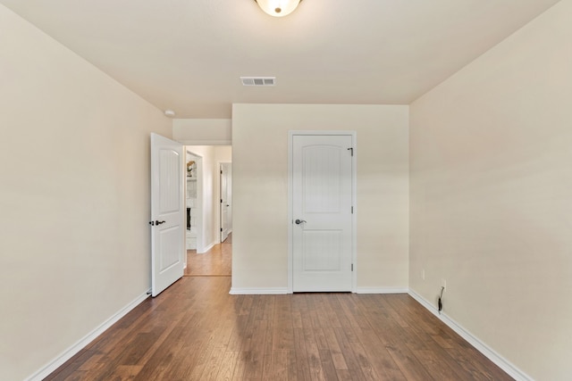 unfurnished bedroom featuring dark hardwood / wood-style flooring