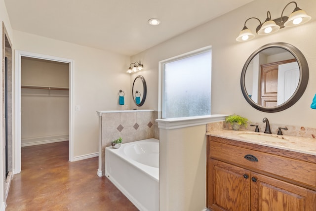 bathroom featuring concrete floors, a bathtub, and vanity