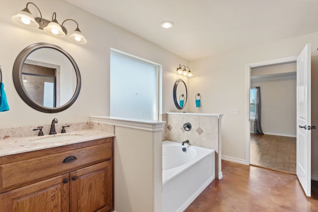 bathroom with vanity, a wealth of natural light, and a tub