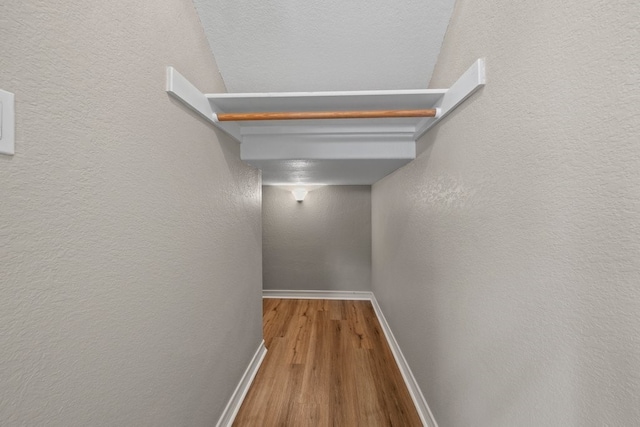 corridor with hardwood / wood-style floors