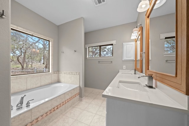 bathroom with tile patterned floors, vanity, and a relaxing tiled tub